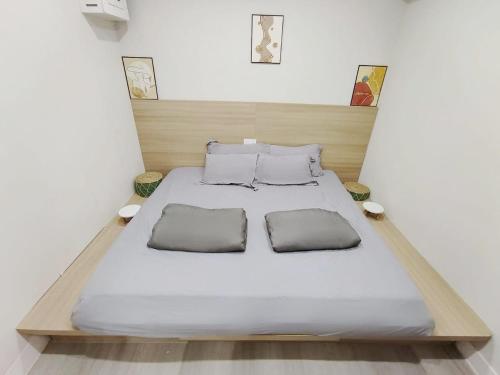 a bed with two pillows on it in a room at Nap Hella Inn in Hong Kong