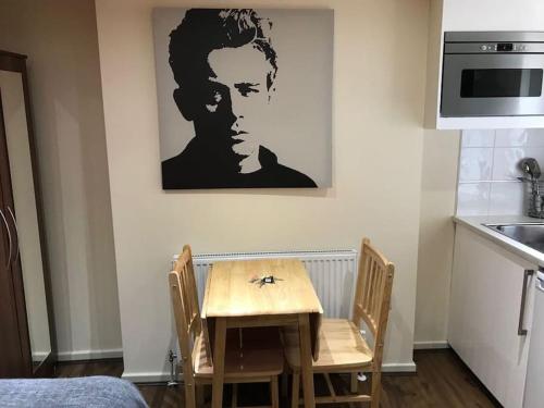 a table and chairs in a kitchen with a picture on the wall at Studio flat London in London