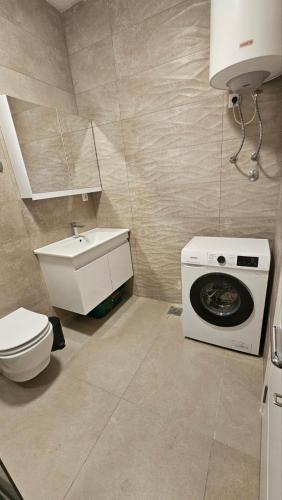 a bathroom with a sink and a washing machine at Apartments Radoman in Ulcinj