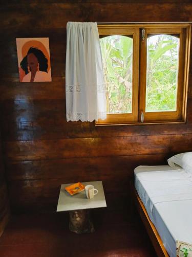 a bedroom with a bed and a window and a table at Big Mama's Little House Casa da Mãe Grande in Porto Alegre