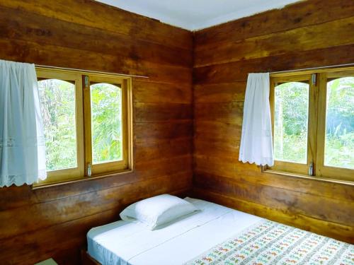 a bedroom with two beds and two windows at Big Mama's Little House Casa da Mãe Grande in Porto Alegre