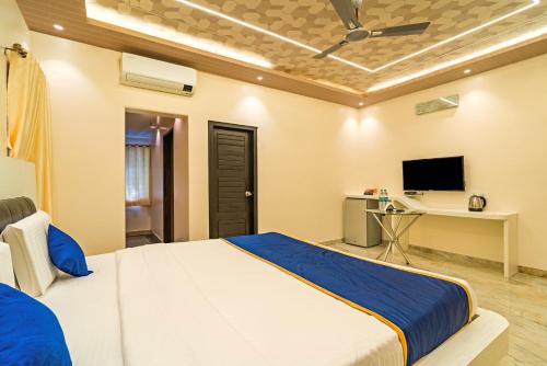 a bedroom with a large bed and a tv at The Venue By Seasons Suites- in Dod Ballāpur