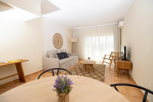 a living room with a table and a couch at Pestana Palm Gardens in Carvoeiro