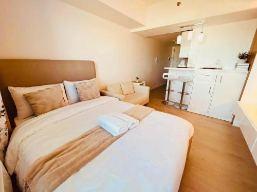 a bedroom with a large bed and a kitchen at Elitista Chateau Azure North Pampanga in San Fernando