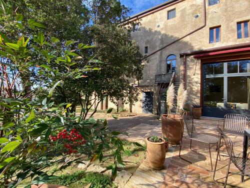 a patio with chairs and plants in front of a building at B&B lo scudaio Palazzo Marchionneschi in Montescudaio