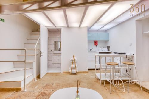 Habitación con escalera y cocina con paredes blancas. en Authentic & cosy duplex home in charming Rabat By 360 Estates, en Rabat