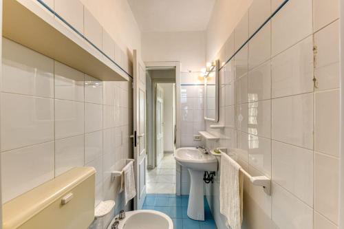 Baño blanco con lavabo y aseo en Casa Trilussa Trilocale by Salento com, en Torre Mozza