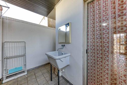baño con lavabo y ventana en Casa Trilussa Trilocale by Salento com, en Torre Mozza