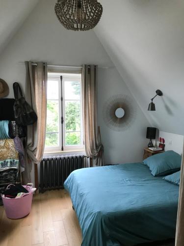 Un dormitorio con una cama azul y una ventana en villa santa lucia en Pornic