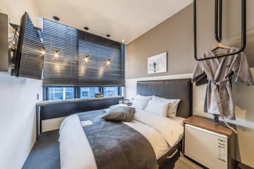 a bedroom with a large bed and a window at H Avenue Hotel Gwangalli branch in Busan