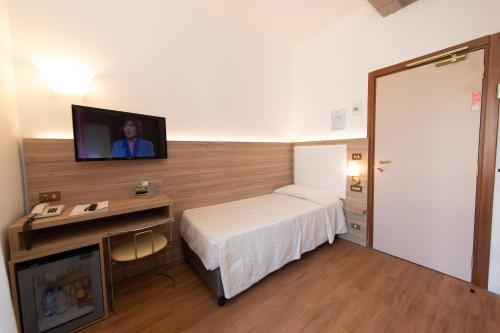 a hotel room with a bed and a flat screen tv at Hotel Re Enzo in Bologna