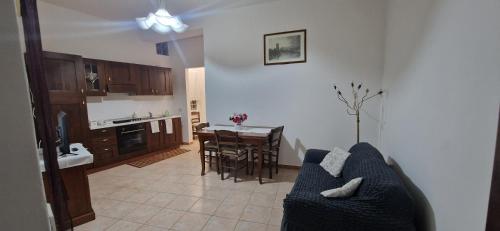 a living room with a blue couch and a kitchen at Casa Grilla in Assemini