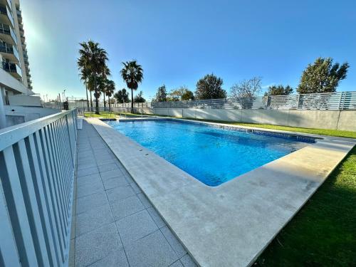 uma piscina ao lado de uma cerca branca em Habitación en la Bahía de Cádiz em San Fernando