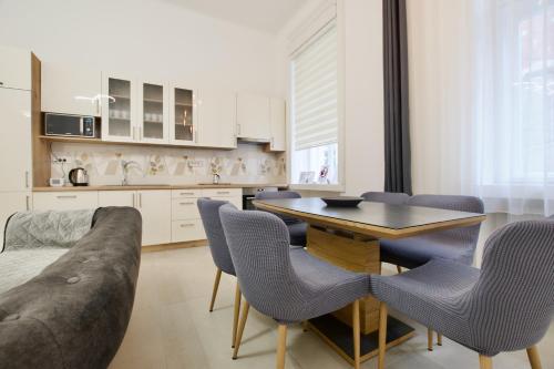 een keuken met een tafel en stoelen en een bank bij Premium Apartment by Hi5- Near New York Cafe in Boedapest