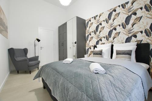 een slaapkamer met een groot bed en een stoel bij Premium Apartment by Hi5- Near New York Cafe in Boedapest