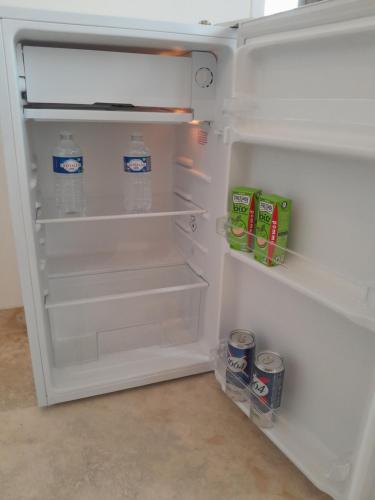 an open refrigerator with milk and cans in it at Casa Mia, chambre privée en Provence in LʼIsle-sur-la-Sorgue