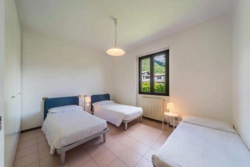 a room with two beds and a window at Villa Rita in Domaso