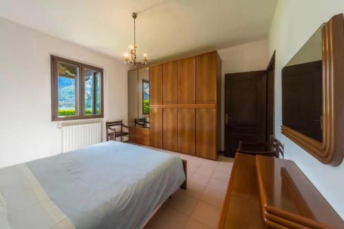 a bedroom with a bed and a desk and a television at Villa Rita in Domaso