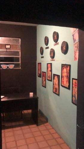 Cette chambre est dotée d'un mur avec des photos sur le mur. dans l'établissement Hostel Vegaspub1600 Experiência, à Campina Grande
