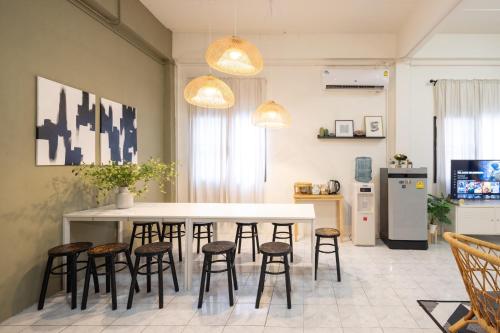 a kitchen with a white table and stools at Bai Bua House Chatuchak in Ban Zong Katiam