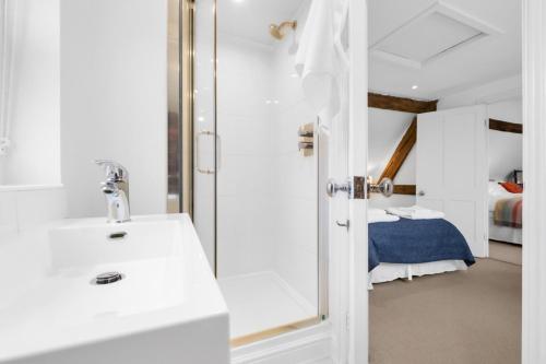 a bathroom with a sink and a shower and a bed at Sparkenhoe House in Nuneaton