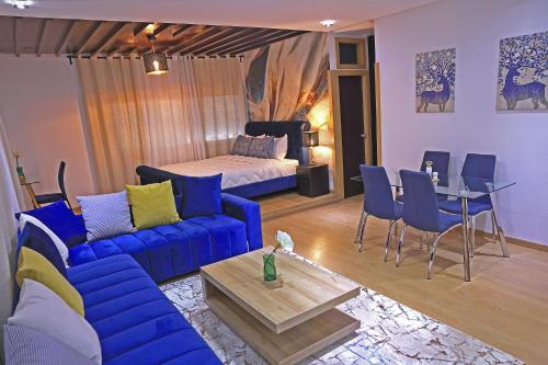 sala de estar con sofá azul y cama en Hotel La Casa Blanca en Tetuán
