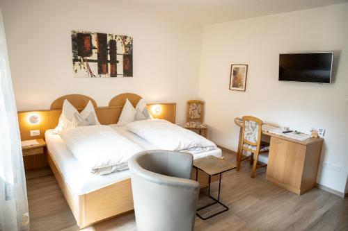 um quarto de hotel com uma cama e uma secretária em Garni Meinrad em Ora