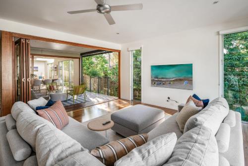 a living room with a couch and a table at Headlands Hideaway - Pet Friendly Home at Moffs in Caloundra
