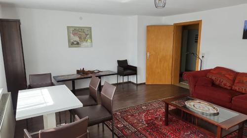 een woonkamer met een rode bank en een tafel bij Ruhige Oase in traumhafter Lage in Rabennest