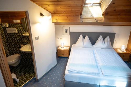 a small bedroom with a bed and a bathroom at Garni Meinrad in Ora/Auer