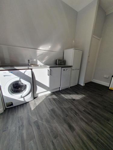 a laundry room with a washer and a refrigerator at McCaig's View in Oban