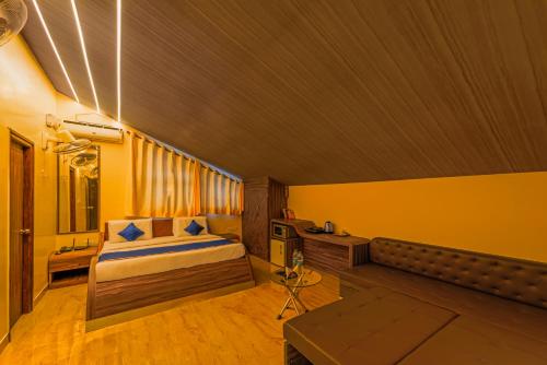 The Venue By Seasons Suites- في Dod Ballāpur: غرفة نوم فيها سرير وتلفزيون