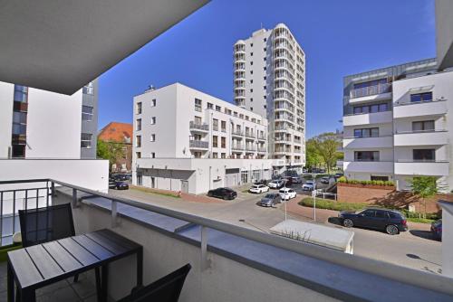 einen Balkon mit Blick auf eine Straße und Gebäude in der Unterkunft Platan - Apartamenty Bryza in Świnoujście