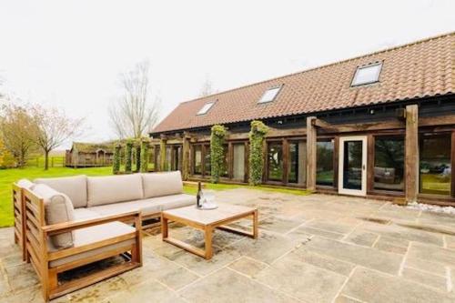 a patio with a couch and a table in front of a house at Newmarket Gem 5-Bedroom Home with Game Room and Cozy Spaces in Brinkley