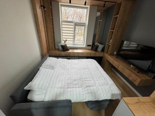 a small bedroom with a bed and a window at Cathedral Park Modern studio in Chişinău