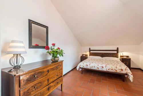 a bedroom with a bed and a dresser with a lamp at Villa Rita in Domaso