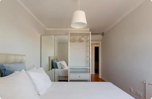 una camera con letto bianco e specchio di Algarve dream seaview apartment w/pool near beach a Porches