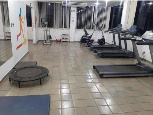 een fitnessruimte met loopbanden en crosstrainers bij Flat Bassano Vaccarini in Ribeirão Preto