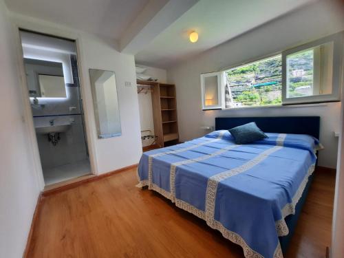- une chambre avec un lit bleu et un lavabo dans l'établissement Candy Candy holiday house, à Minori