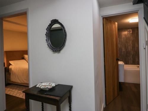 Zimmer mit einem Spiegel, einem Bett und einem Tisch in der Unterkunft The Barn in Seascale