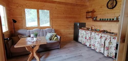 a living room with a table and a kitchen at Chatka na Wzgórzu, Staw z możliwością łowienia ryb, Cisza, Spokój in Barczewo