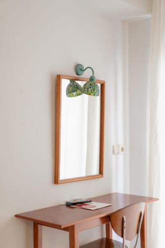 a mirror on a wall next to a wooden table at Hotel Santa Faz in Benidorm