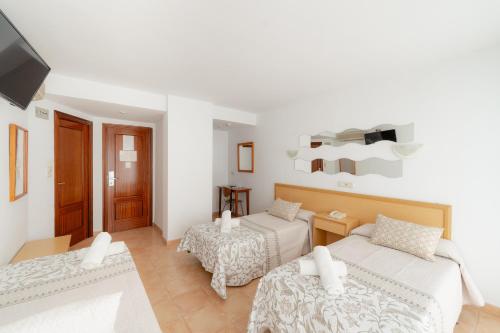 Habitación blanca con 2 camas y TV. en Hotel Santa Faz, en Benidorm