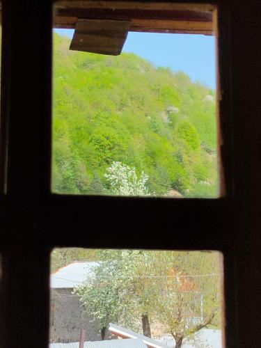 una ventana con vistas a una colina verde en waterfall, en Mestia