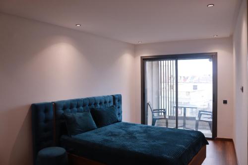 een slaapkamer met een blauw bed en een balkon bij LUXE APPARTEMENT in Casablanca