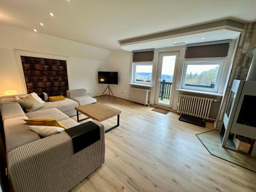a living room with a couch and a tv at Haus Schneekappe (Winterberg) in Winterberg