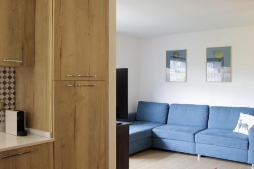 un soggiorno con divano blu e una cucina di CASA SOFIA - Dolomiti Affitti a Cavalese