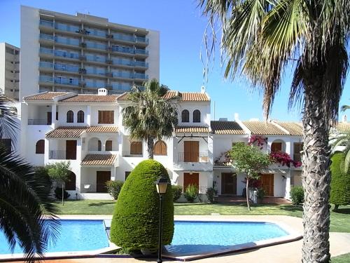 une villa avec une piscine en face d'un bâtiment dans l'établissement Apartamentos Aldeas de Taray V.v., à La Manga del Mar Meno