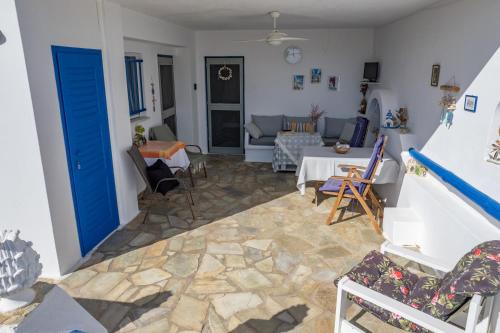 a living room with blue doors and a stone floor at MARKOS' HOUSE in Agiassos