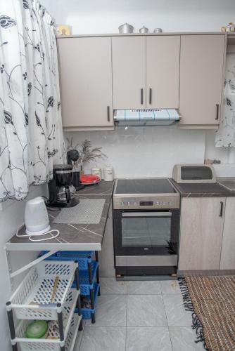 a kitchen with white cabinets and a stove top oven at MARKOS' HOUSE in Agiassos